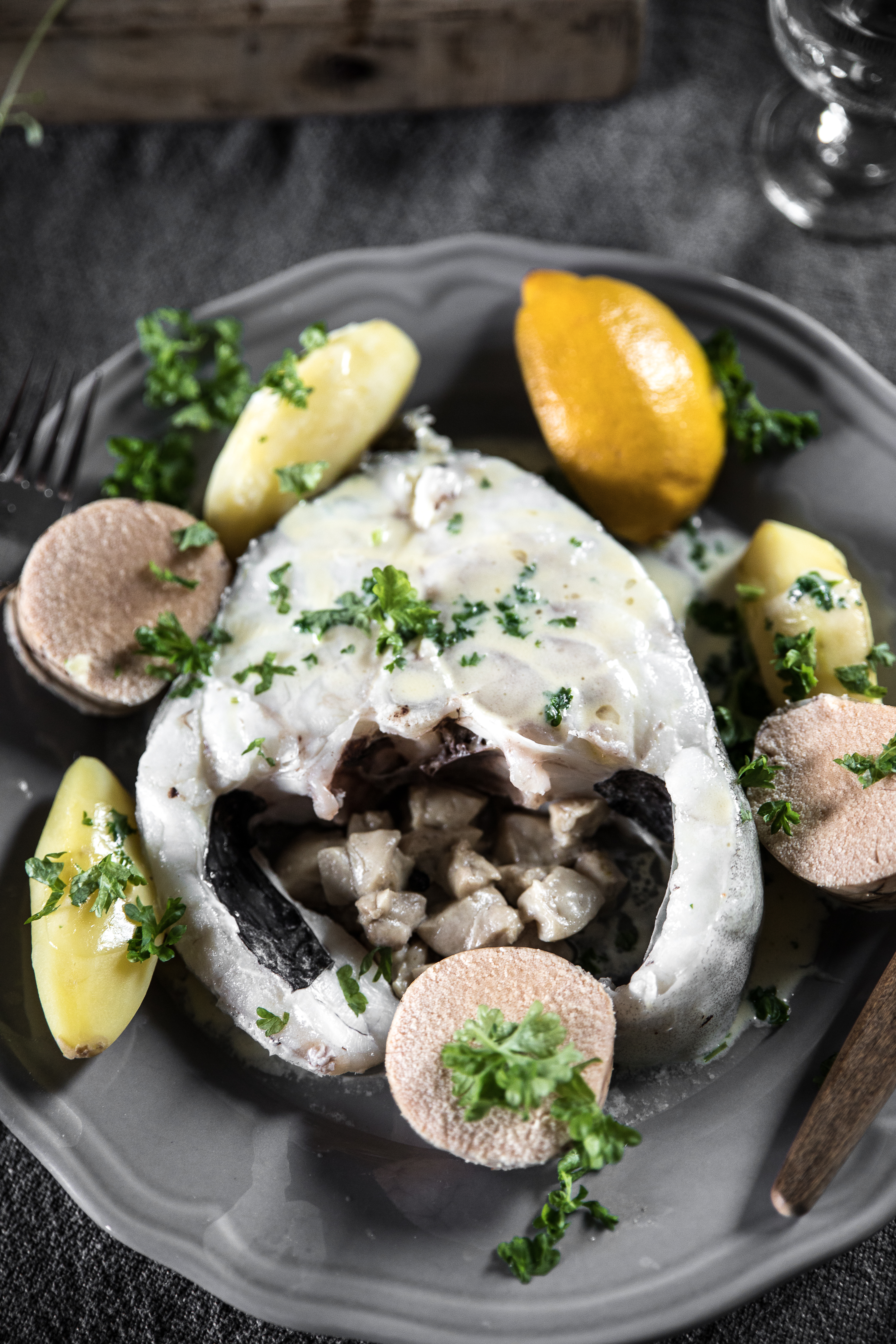 En tallerken på et bord med skreimølje og biter av sitron